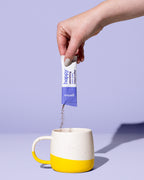 a sachet of astonishing dark roast instant coffee being poured into a coffee mug