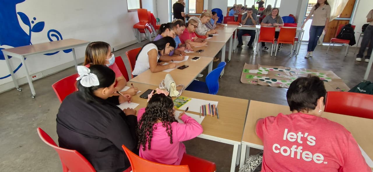 Image of coffee farmers sitting around a table listening to a speaker